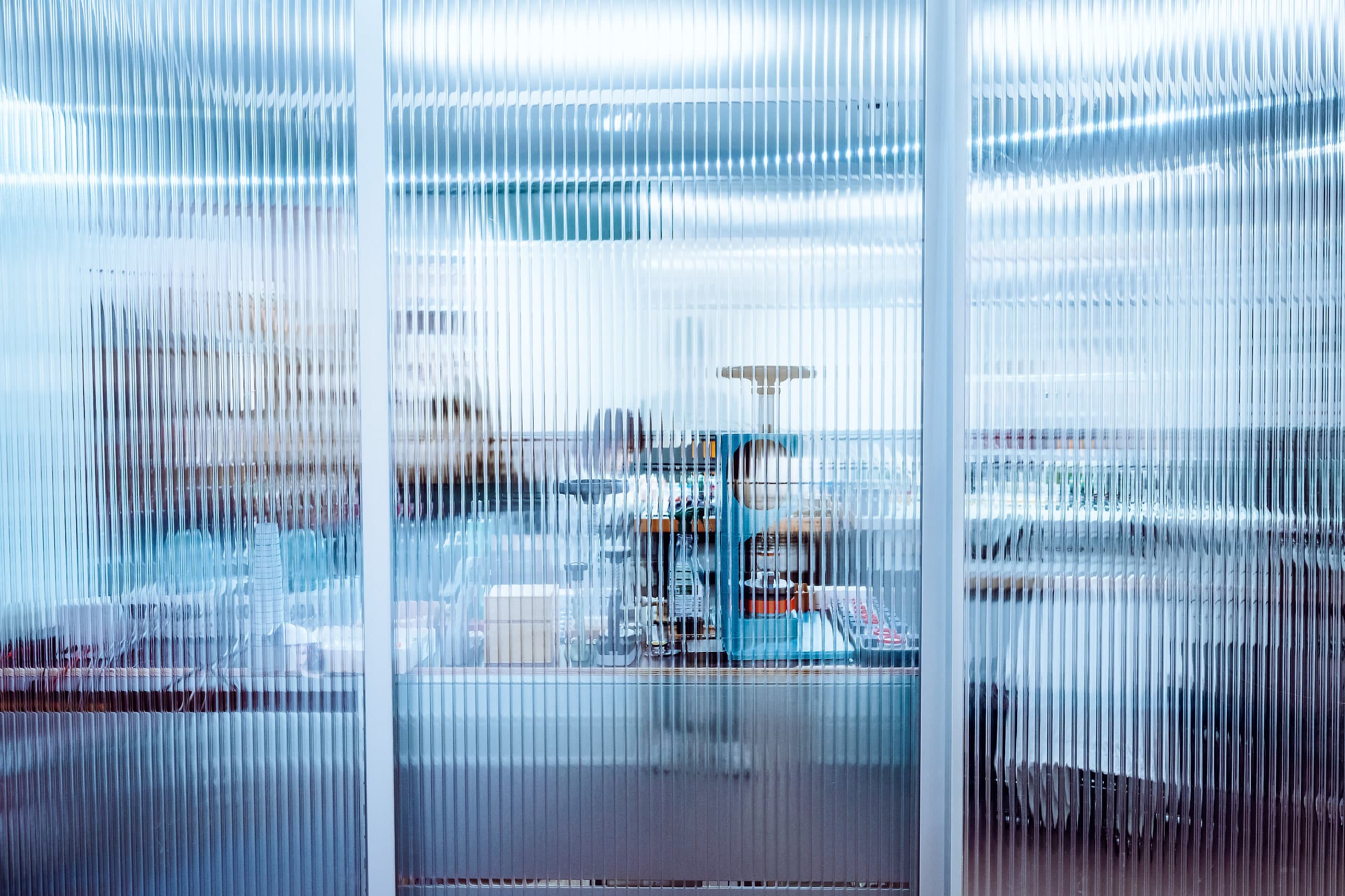 View through the fluted glass wall into the watchmaking workshop